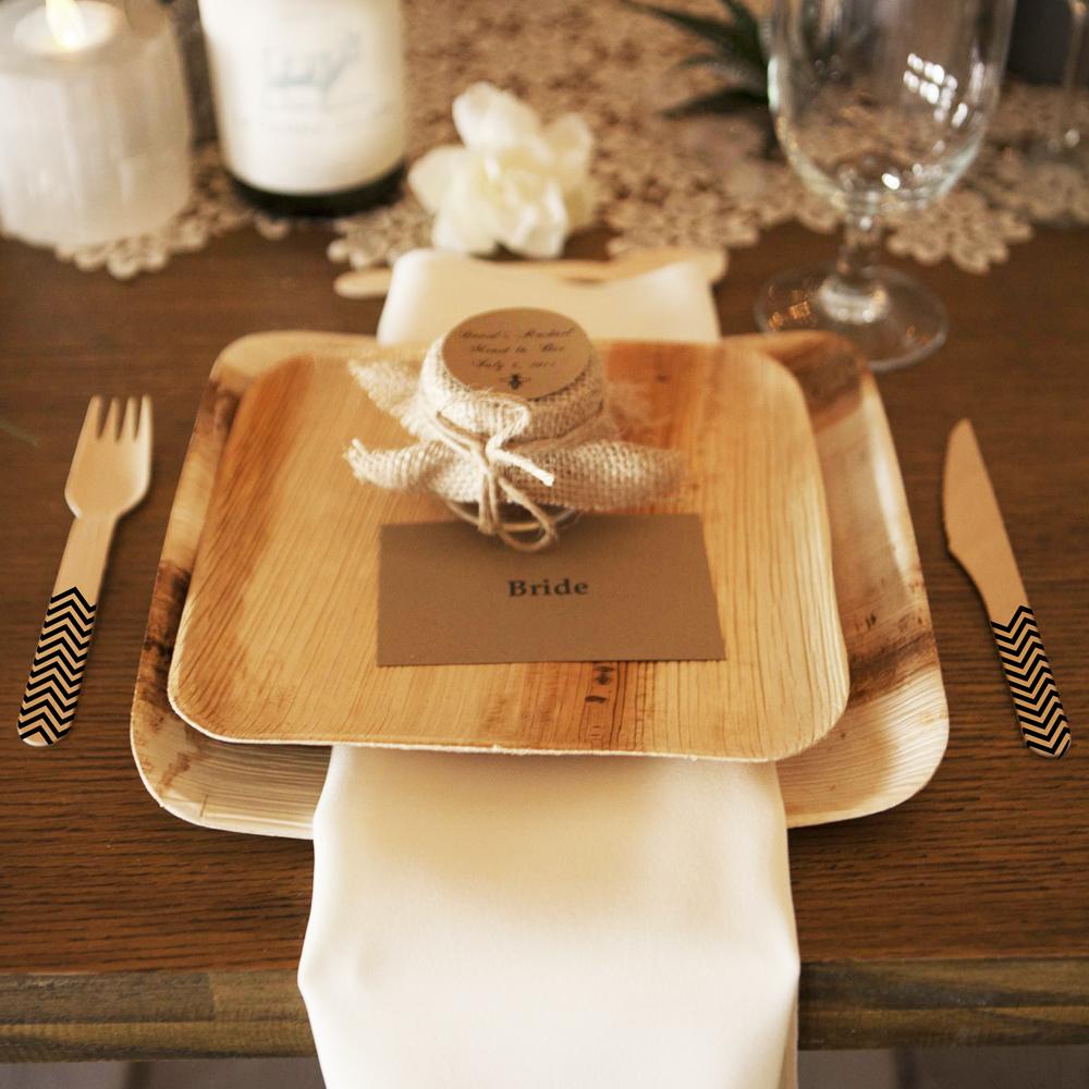 Wedding place setting with palm leaf plates and black chevron birchwood cutlery